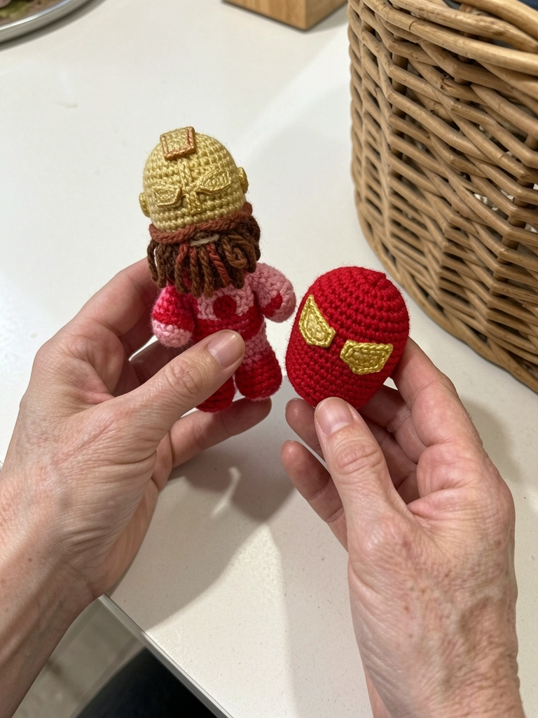 Boneco de crochê do Homem de Ferro com armadura vermelha e dourada, em fundo neutro.